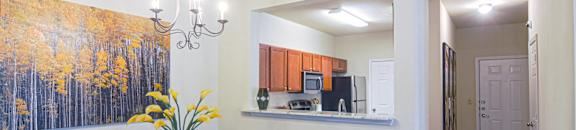 a dining room with a table and chairs and a kitchen at The Madison Apartment Homes in Texas 75703