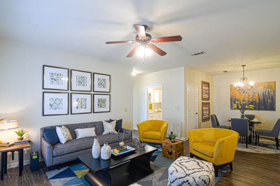 a living room with a kitchen in the background at The Madison Apartment Homes in Tyler, Texas