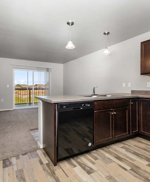 A kitchen with a white countertop and wooden flooring.