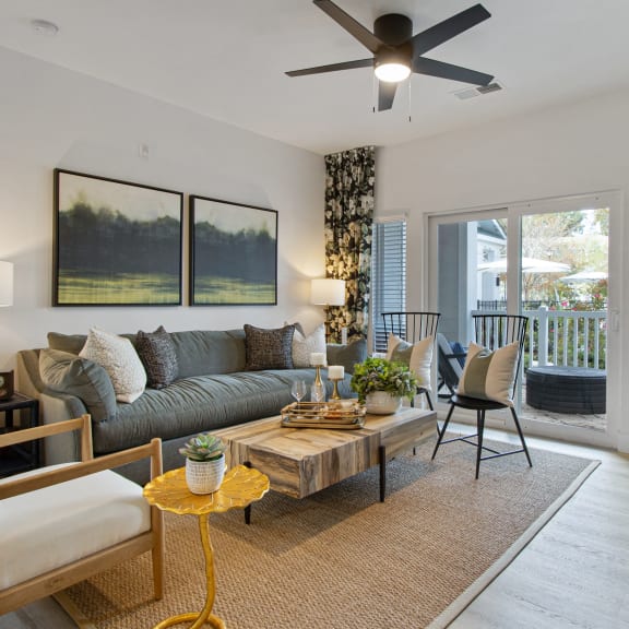 a living room with a couch and a coffee table and a ceiling fan