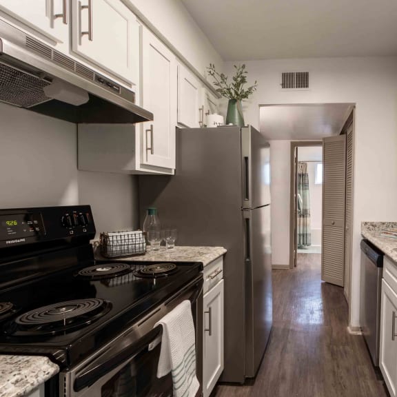 a kitchen with stainless steel appliances and marble counter tops