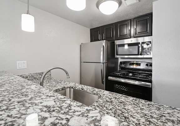 A kitchen with granite countertops and stainless steel appliances.