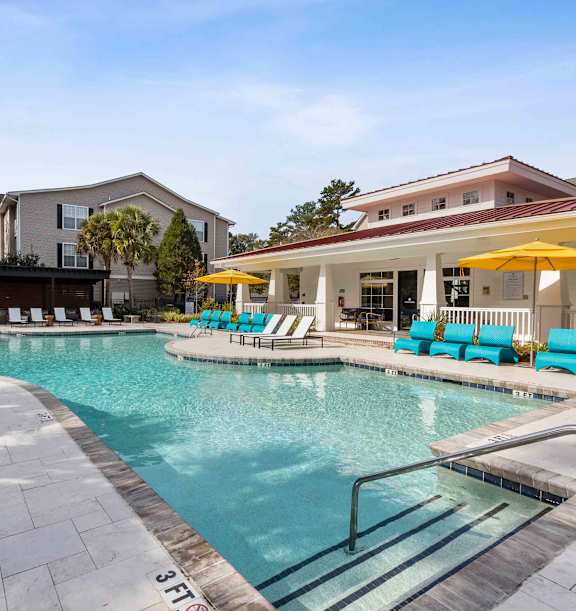 A swimming pool with a slide and sun loungers.