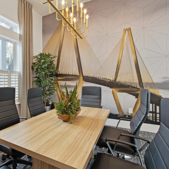 a room with a large table with chairs and a chandelier hanging from the ceiling