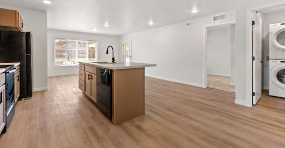 A kitchen with wooden floors and appliances.
