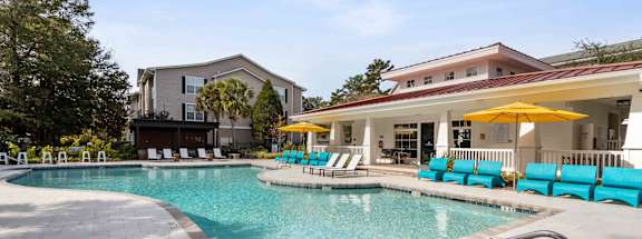 A swimming pool with a slide and sun loungers.