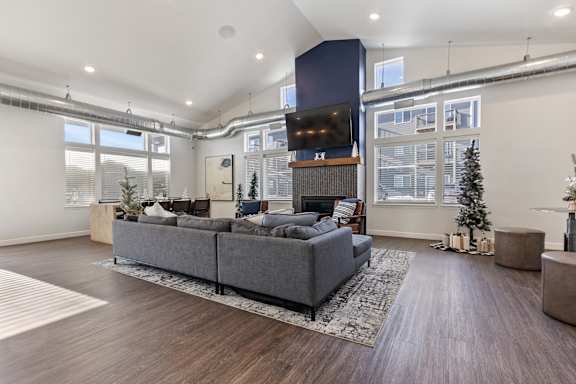 A modern living room with a grey sofa and a wooden floor.