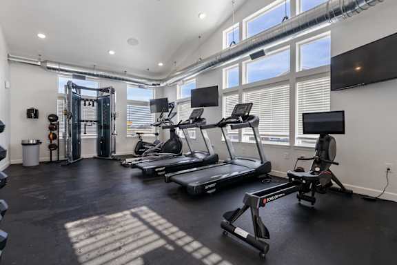 A gym with treadmills and elliptical machines.