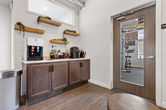 A kitchen with wooden cabinets and a white wall.