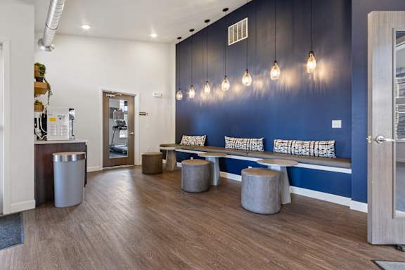 A modern office lobby with a bench, trash can, and lights.