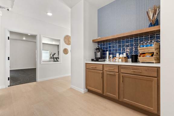 A kitchen with brown cabinets and a blue tile backsplash.