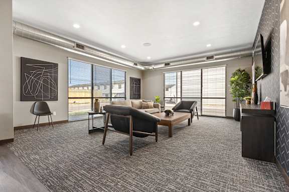 A modern living room with a grey carpet and a large window.