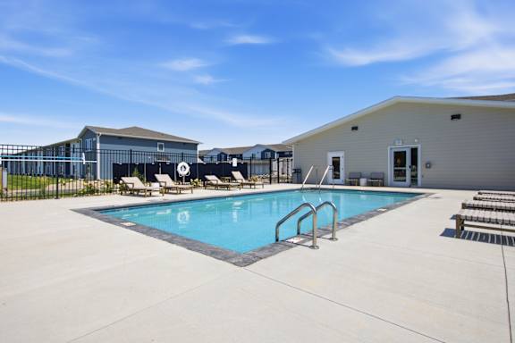 A pool with a metal ladder and a metal fence.
