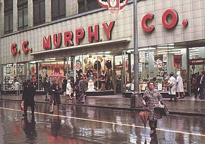 a group of people walking in the rain in front of a store at Market Square Place, Pittsburgh, PA, 15222
