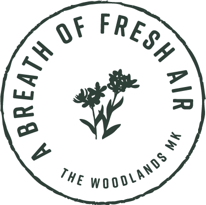 A black and white logo for Breath of Fresh Air featuring flowers at The Woodlands Apartments, Milton Keynes, MK5 6GS