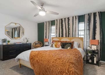 a bedroom with green walls and an orange blanket on the bed