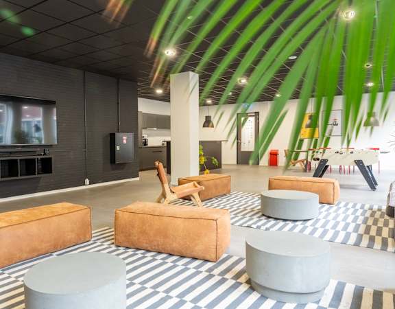 A room with a striped carpet and a television on the wall.