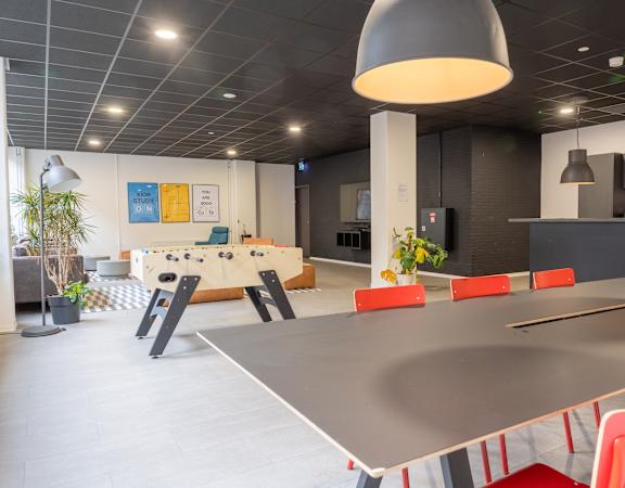 A modern dining area with a long table and chairs.