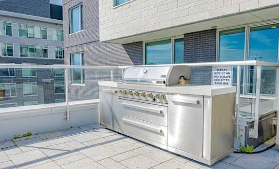 a stainless steel barbecue grill on the patio of a building