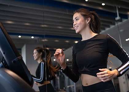 a group of people running on a treadmill in a gym