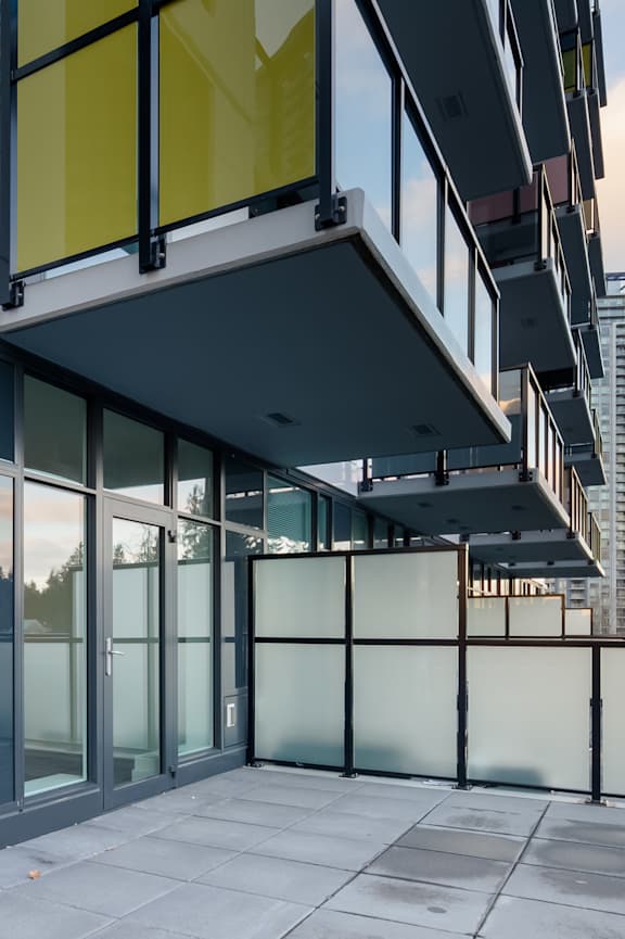 A modern building with glass walls and a balcony.