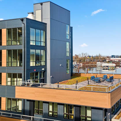 A modern building with a balcony overlooking a body of water.