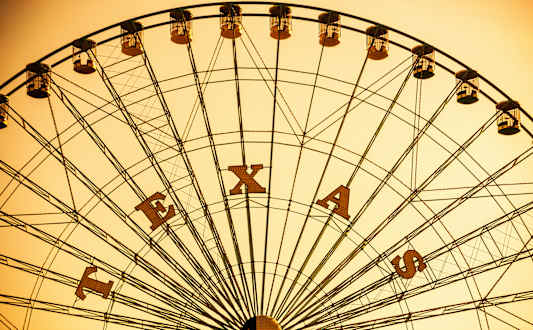 A Ferris wheel with the letters E, X, A, and S on it.