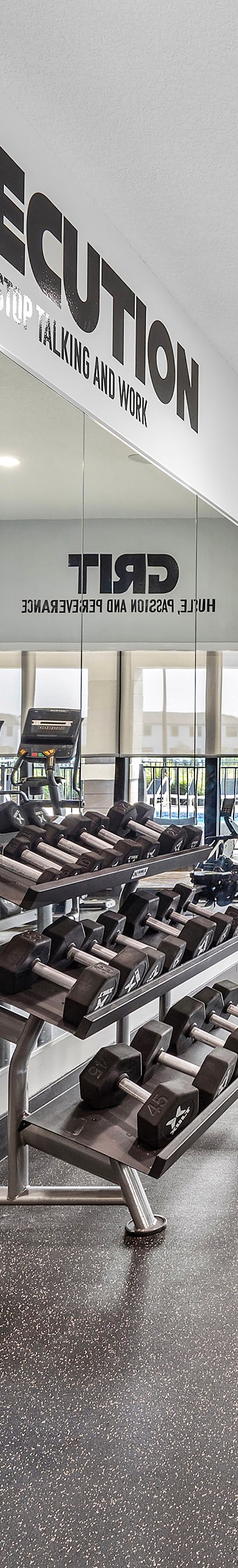 a gym with weights and cardio equipment in a building with glass doors