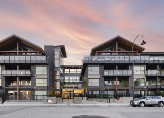 a rendering of a large apartment building with a car parked in front of it