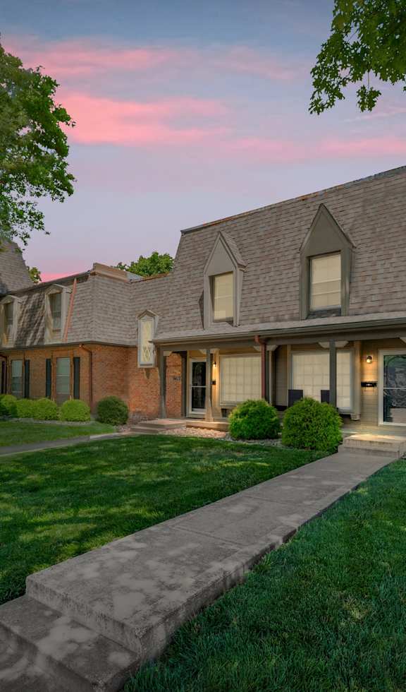 A house with a brick facade and a large front yard.