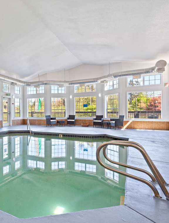 A large indoor swimming pool with a diving board.