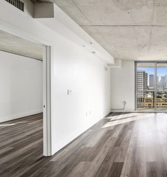 a living room with hardwood floors and a door to a balcony