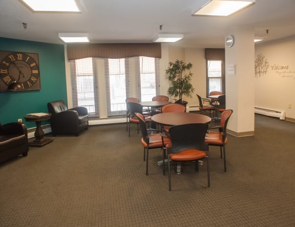 a room with a table and chairs and a clock on the wall