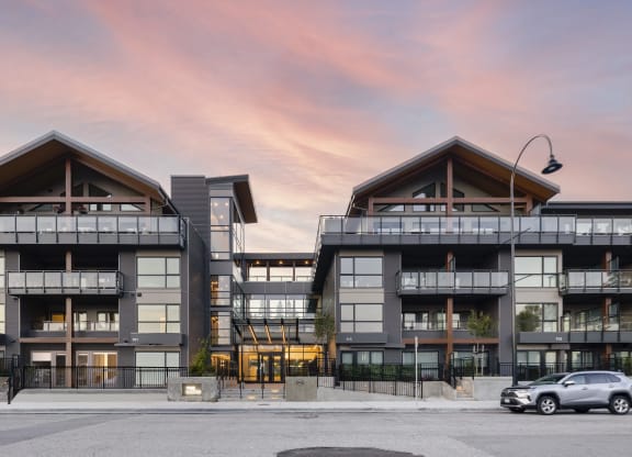 a rendering of a large apartment building with a car parked in front of it