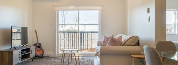 a living room with a couch and a chair and a sliding glass door