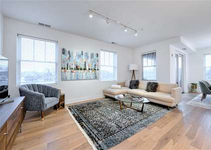 a living room with a couch and two chairs and a rug