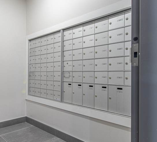 a wall of lockers in a room with white walls and flooring