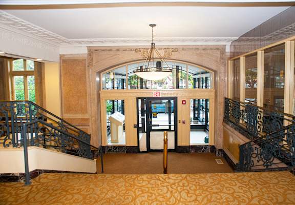 the lobby of a building with stairs and a chandelier