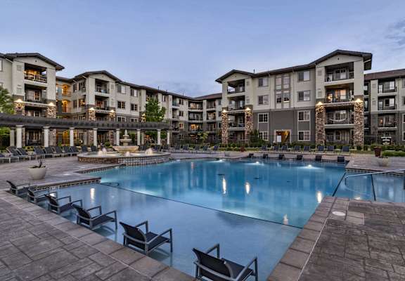 a large blue pool with buildings in the background at Terracina, Broomfield, CO