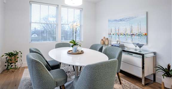 a dining room with a white table and chairs