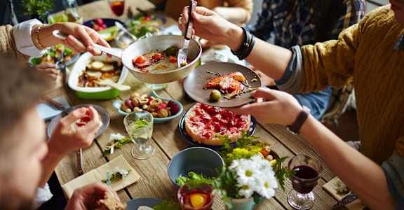 a group of people sitting around a table eating food