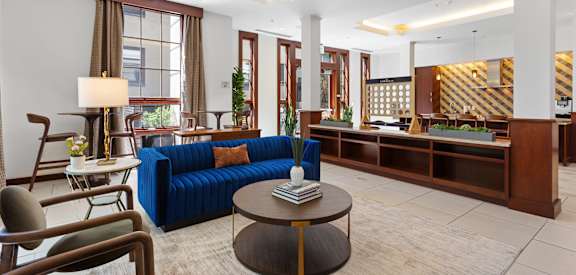 a lobby of a hotel with a blue couch and a coffee table