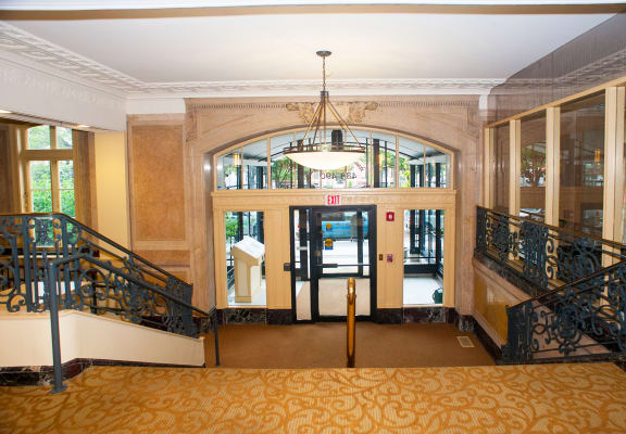the lobby of a building with stairs and a chandelier