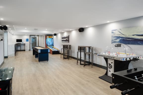 a game room with a pool table and a foosball table in the corner