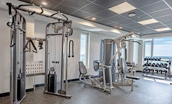 a gym with weights and other exercise equipment in a room with windows