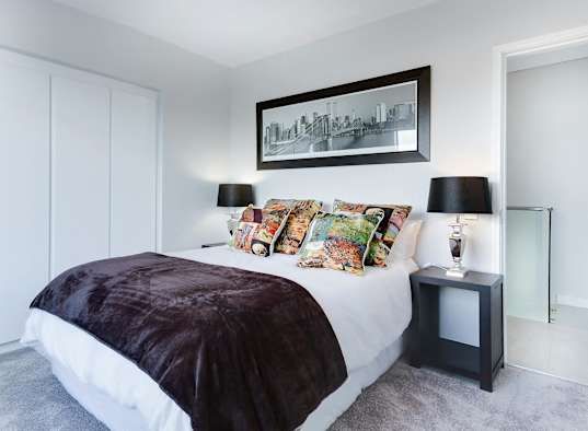 a bedroom with white walls and a bed with pillows