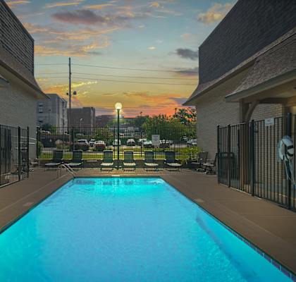 A swimming pool surrounded by a fence and buildings.