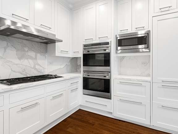 a kitchen with white cabinets and stainless steel appliances at HIGHGROVE, Stamford, Connecticut