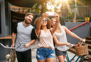 a group of people riding bikes and taking a picture with a cell phone
