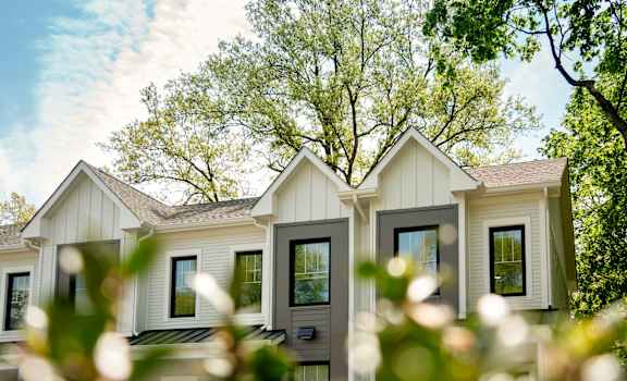 A row of houses with trees in the background.